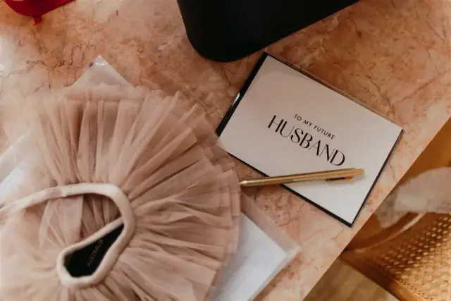 Amy's Bo & Luca wedding gown beside a card for her future husband at The Calile Hotel.