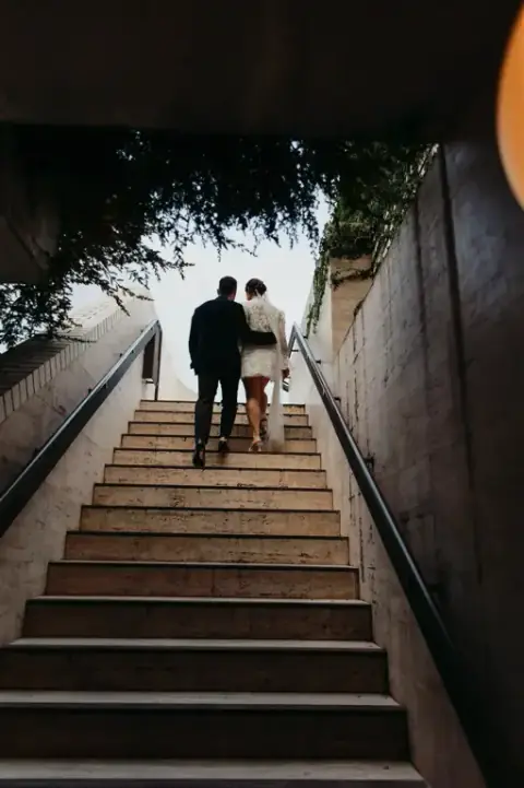 Candid laughter between the newlyweds as they walk along The Calile's open-air corridors lined with tropical plants